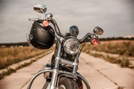 helmet hanging by strap from motorcycle handlebars